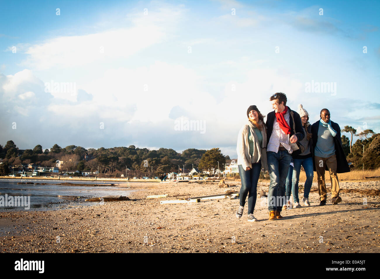 Cinque amici adulti a passeggiare sulla spiaggia Foto Stock