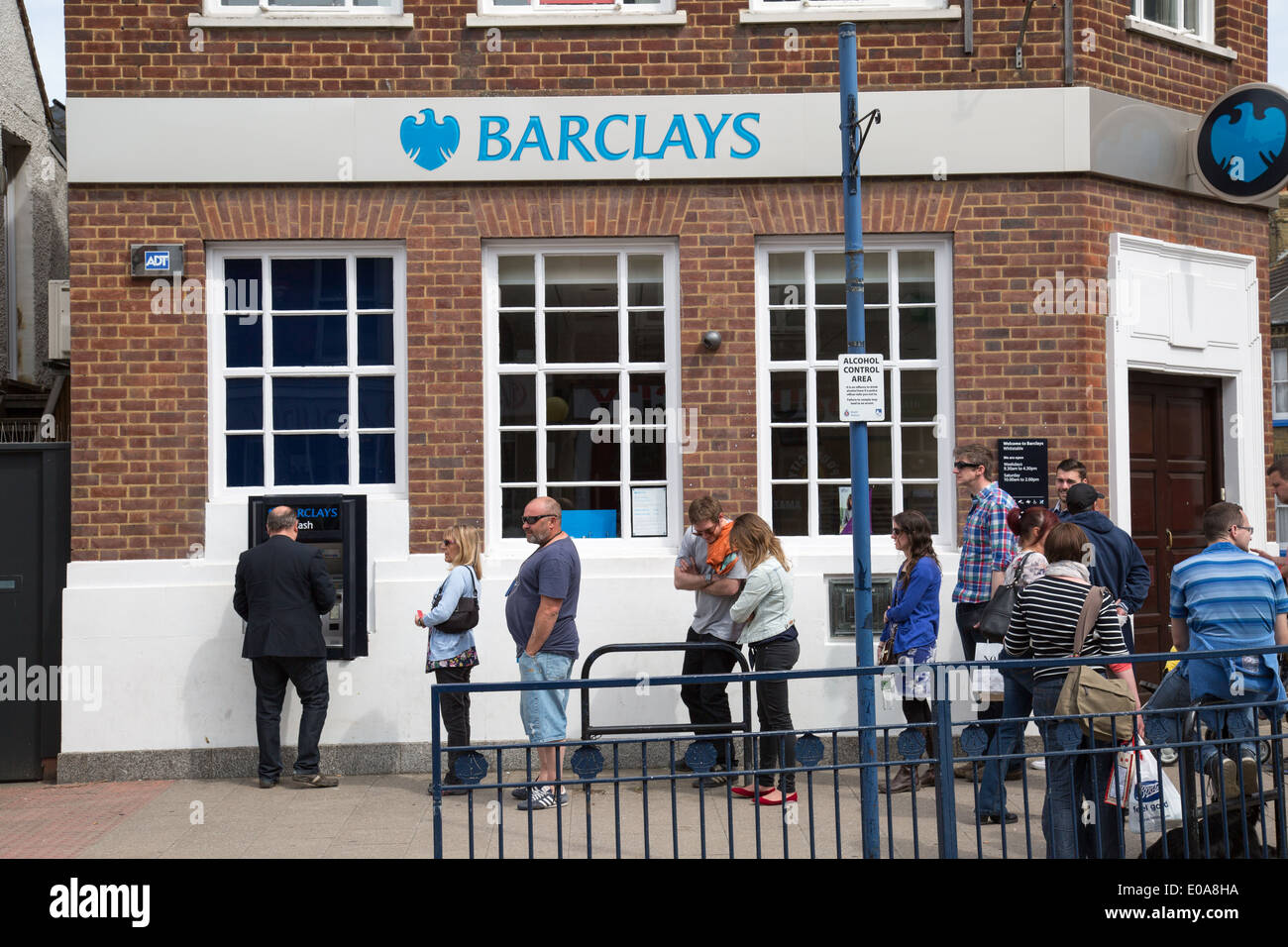 Coda per il distributore di contante presso la Barclays Bank località balneare di Whitstable nel Kent Foto Stock