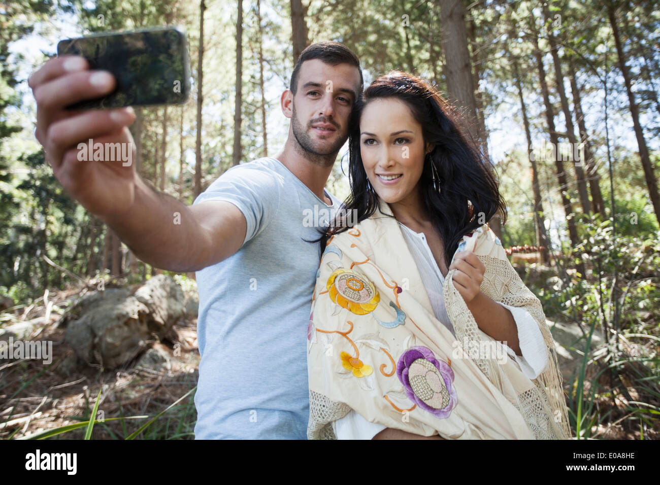 Coppia giovane tenendo self portrait fotografia in foresta Foto Stock