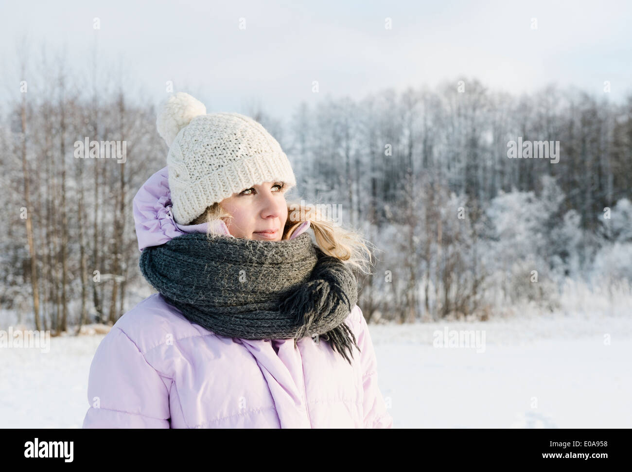 Metà donna adulta indossando abiti invernali in coperta di neve campo Foto Stock