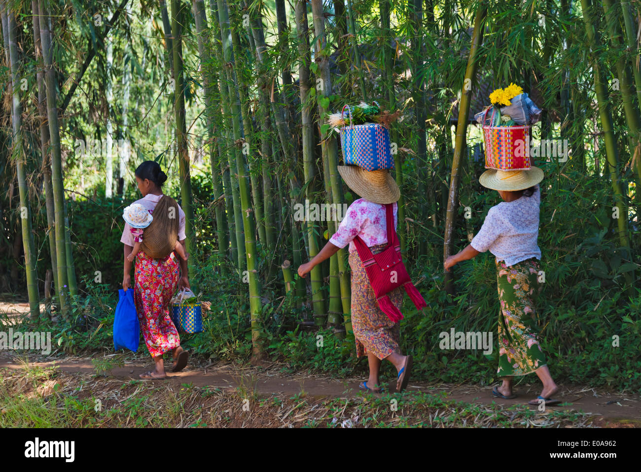 Le donne che trasportano cesto sulla testa sulla riva del Lago Inle, Stato Shan, Myanmar Foto Stock