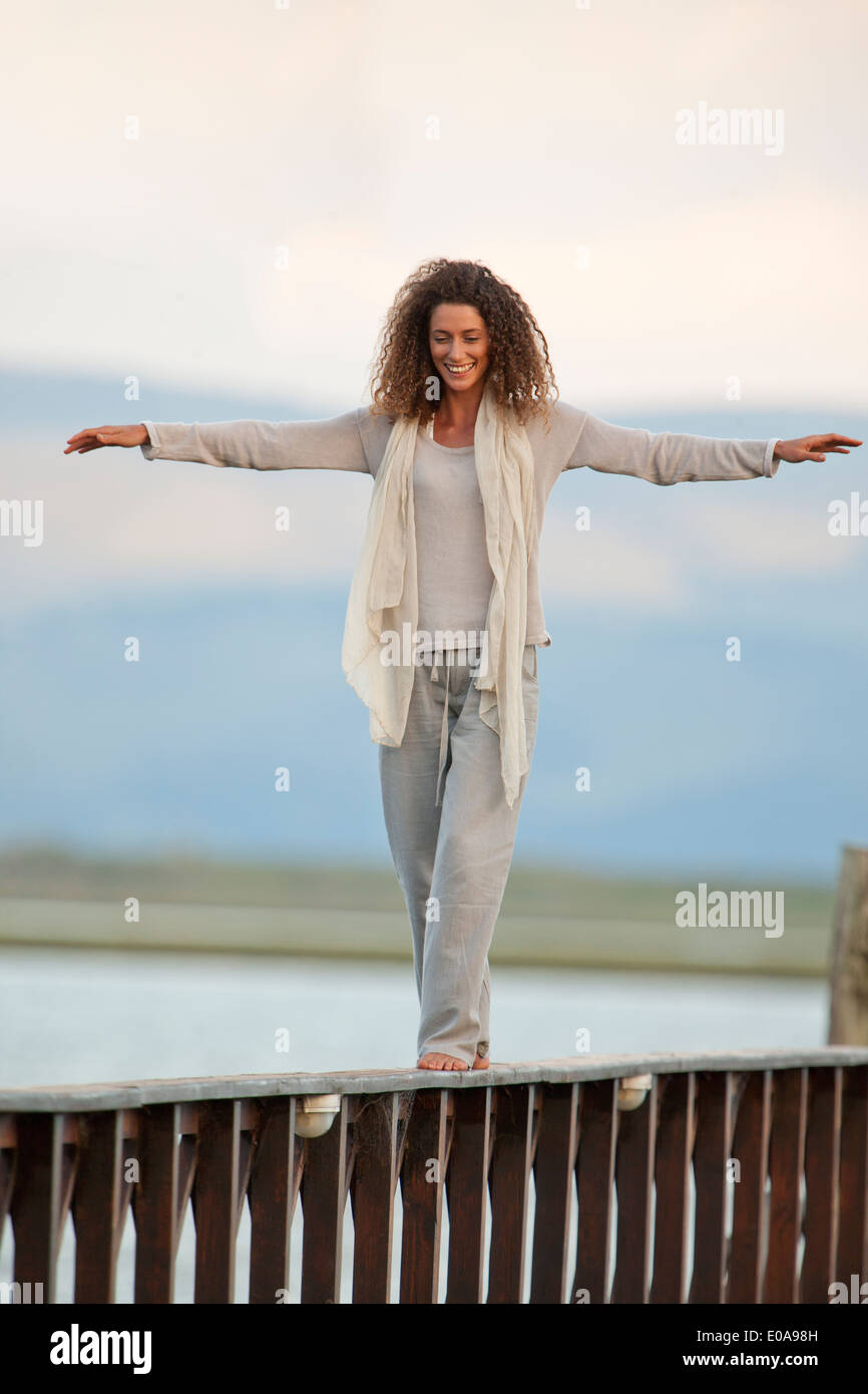 Giovane donna in equilibrio su jetty Foto Stock