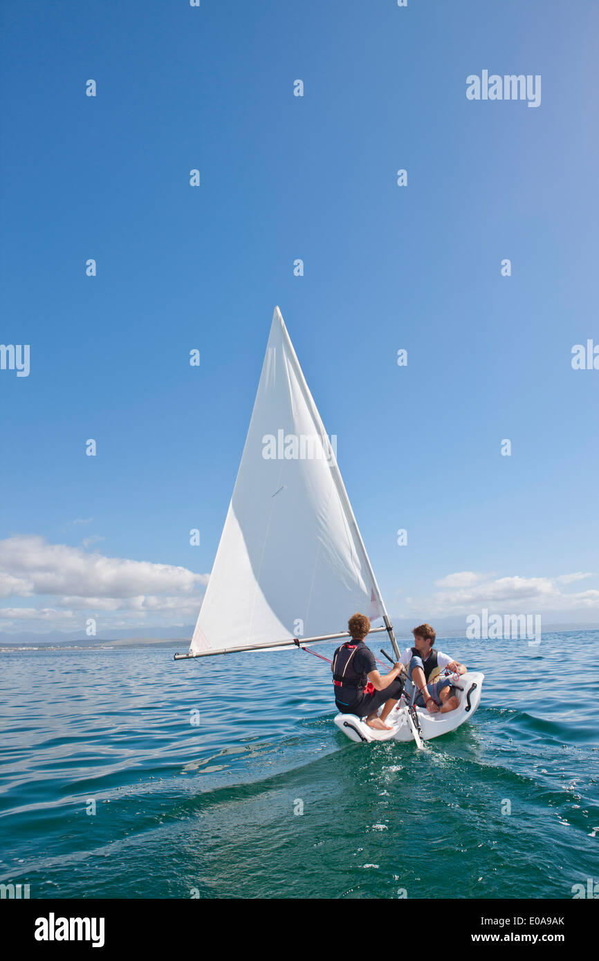 Due giovani uomini di veleggiare in mare Foto Stock