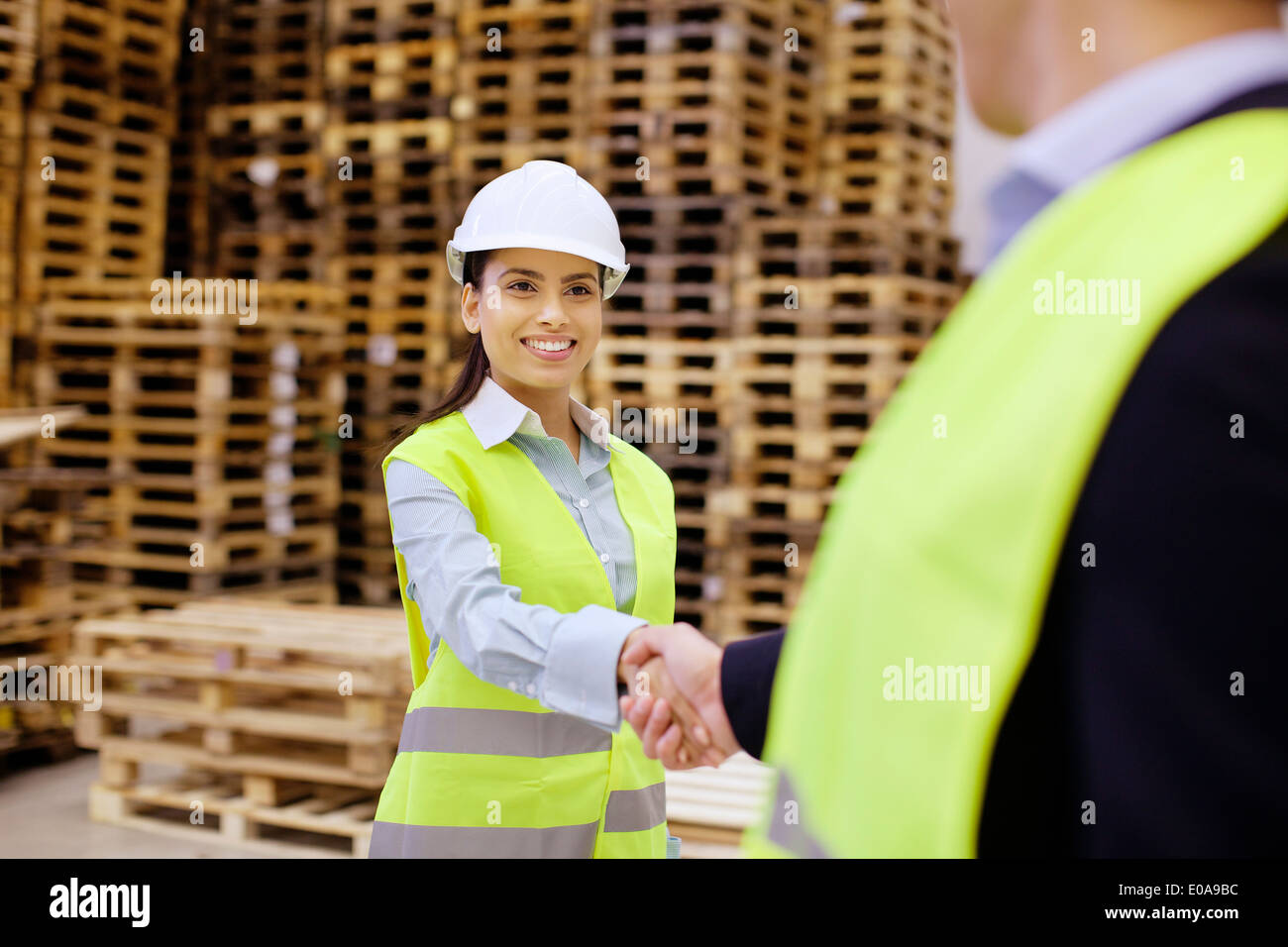 Supervisore e partecipante stringono le mani nel magazzino di distribuzione Foto Stock