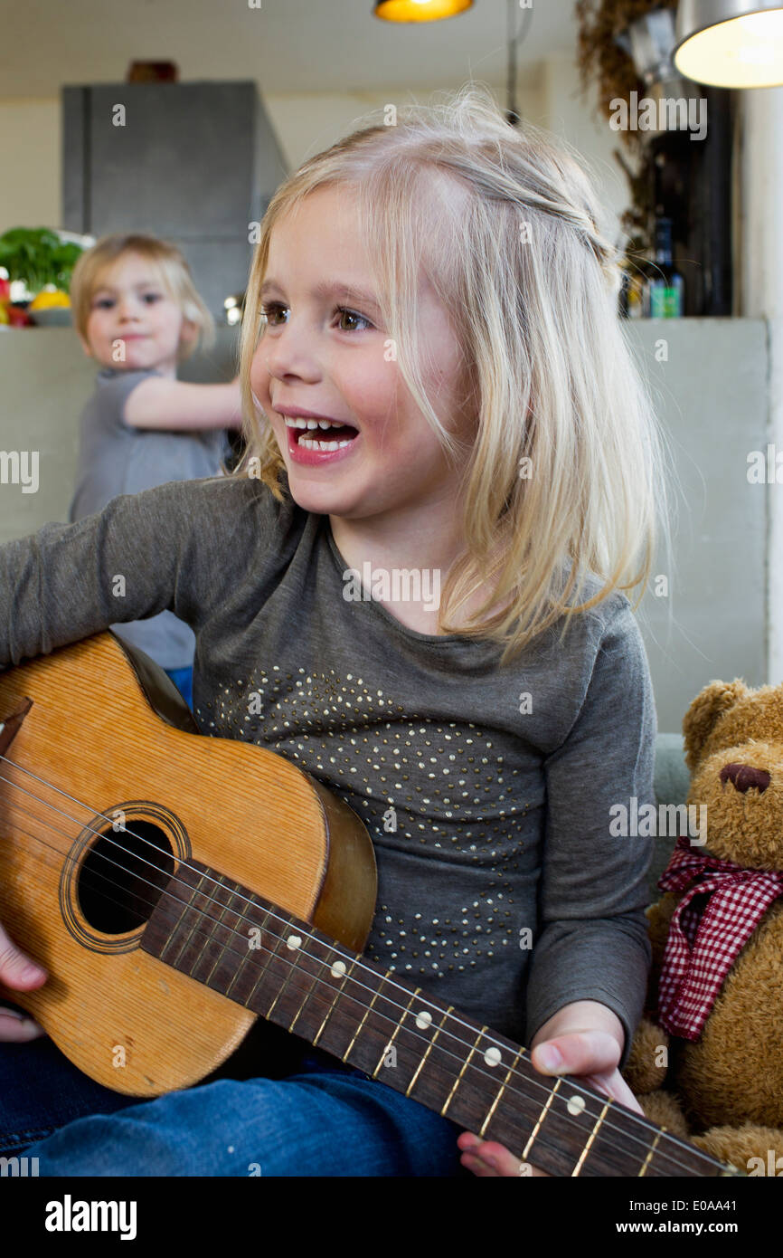 Ragazza giovane suonare la chitarra acustica Foto Stock