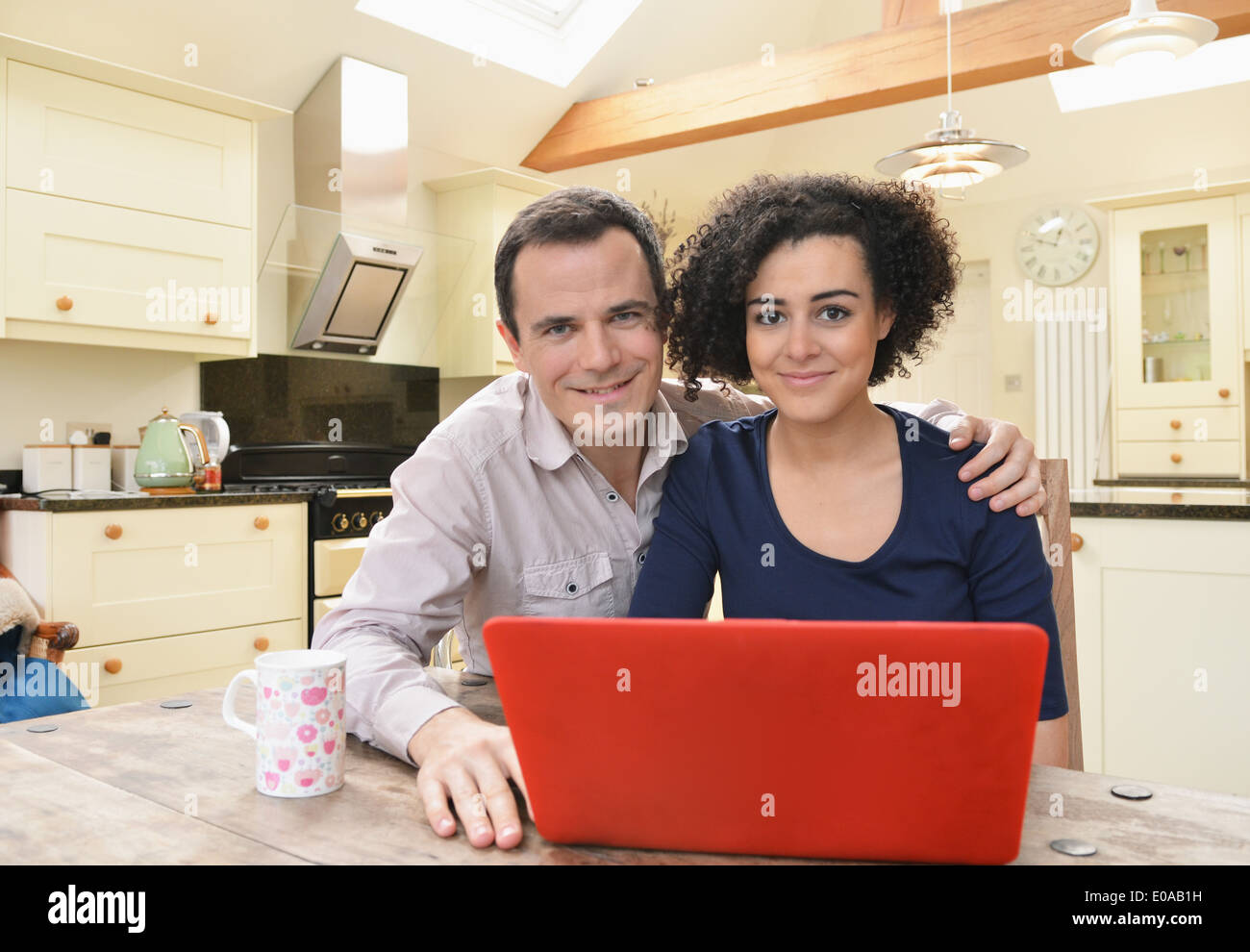 Ritratto di giovane con computer portatile sul tavolo da cucina Foto Stock