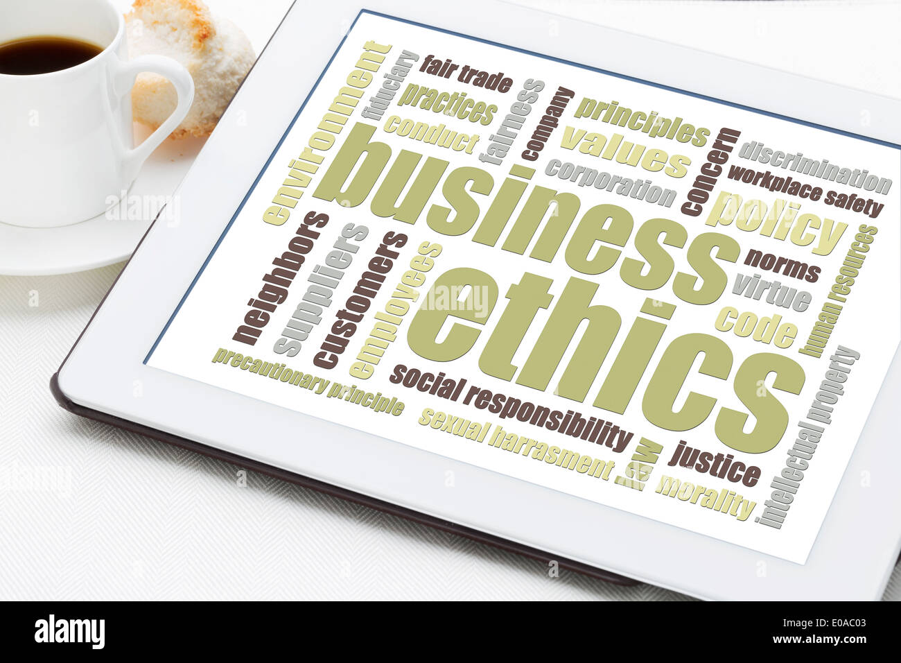 Business Ethics word cloud su una tavoletta digitale con una tazza di caffè Foto Stock