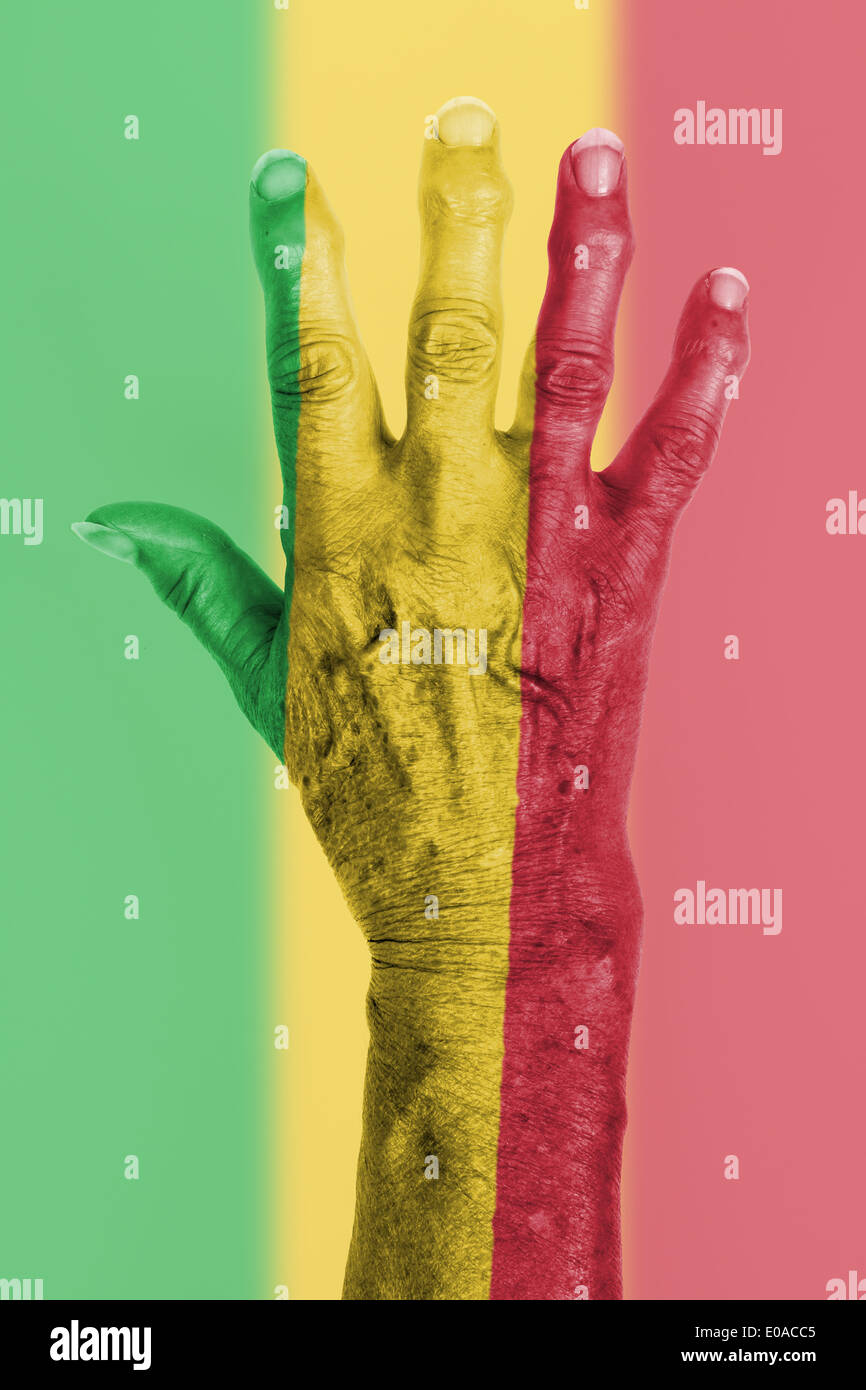La mano di una vecchia donna avvolta nella bandiera del Mali Foto Stock