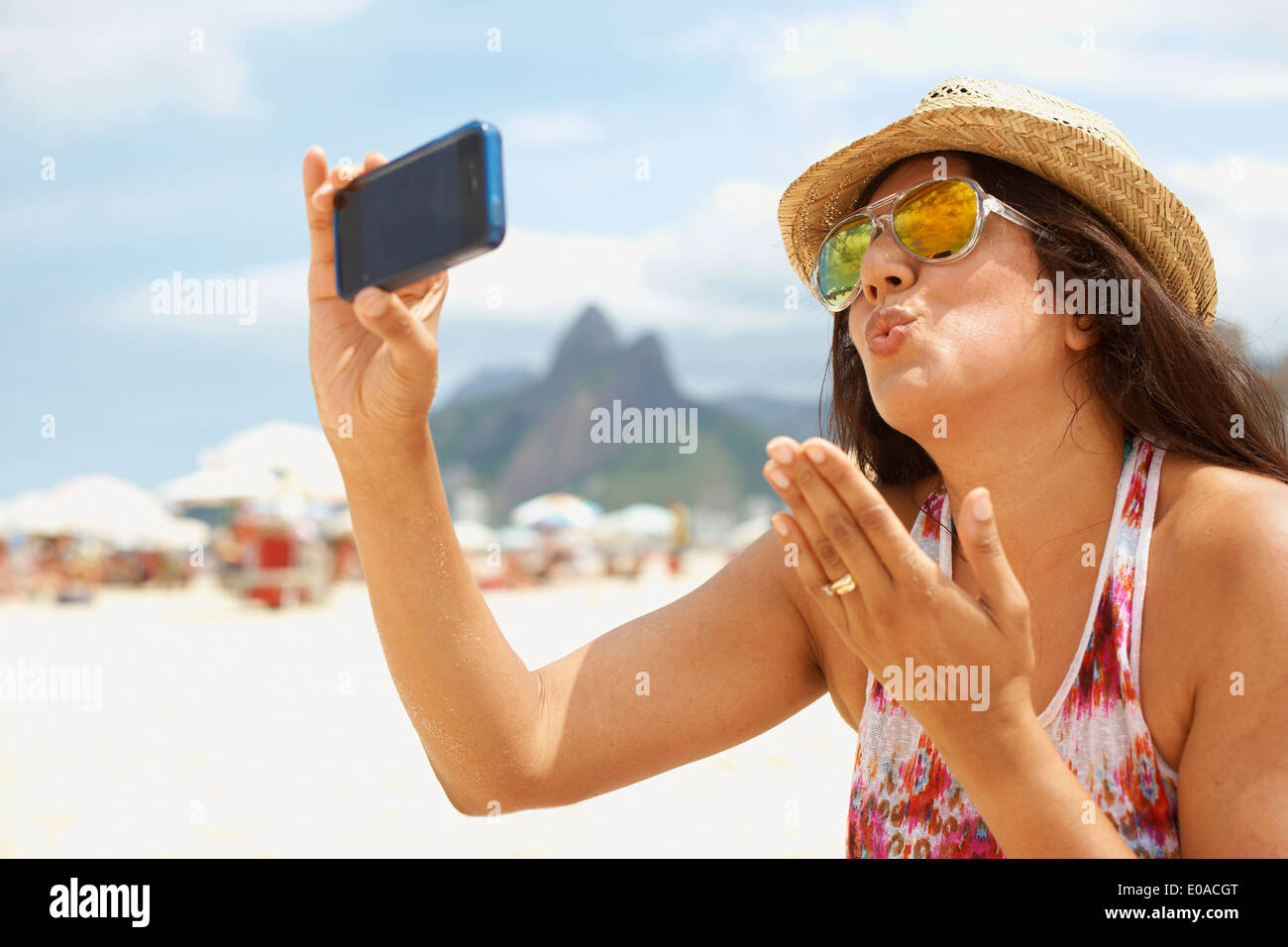 Donna matura prendendo un autoritratto, la spiaggia di Ipanema, Rio de Janeiro, Brasile Foto Stock
