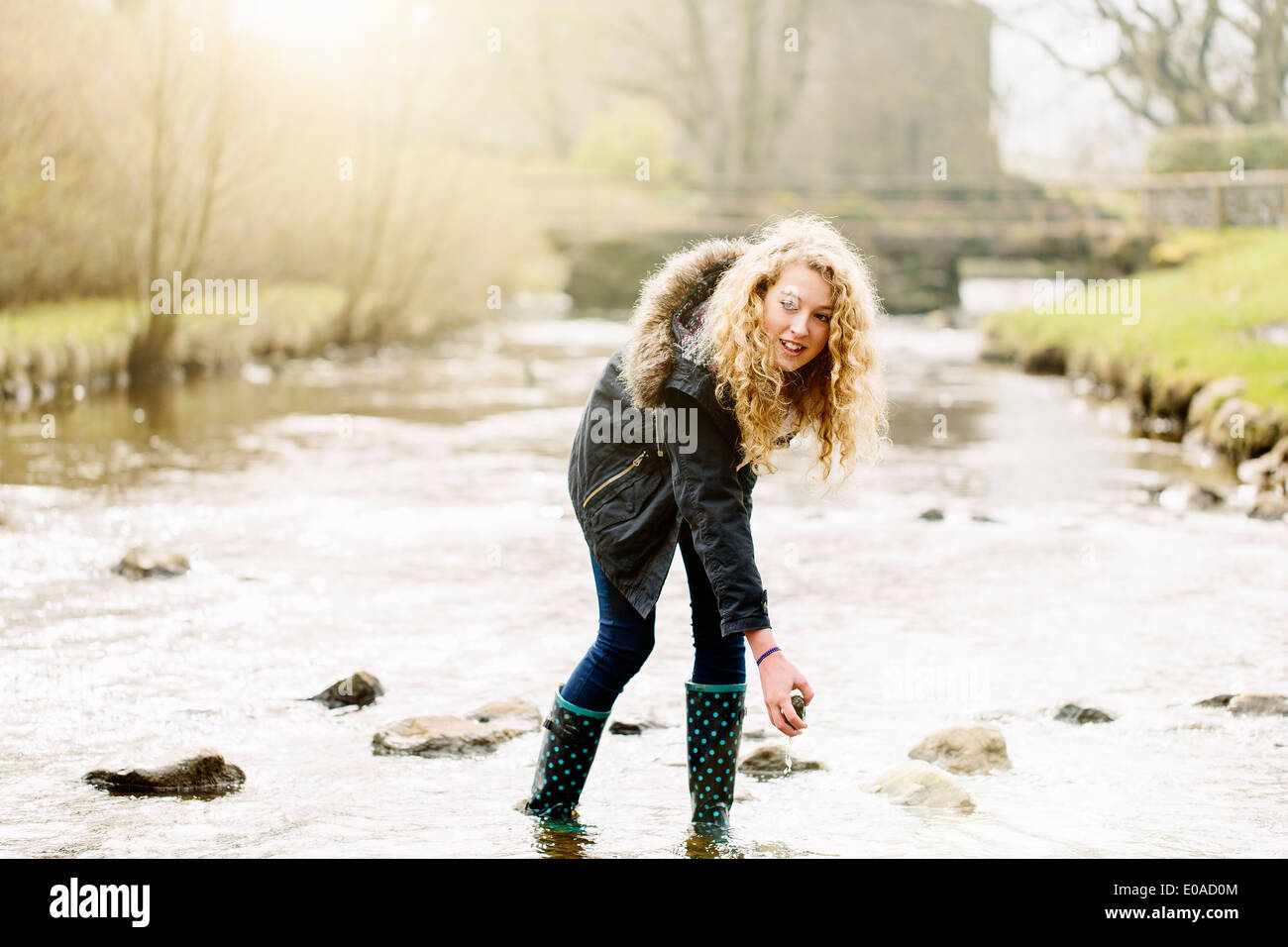 Ragazza adolescente prelievo di pietre di fiume rurale Foto Stock