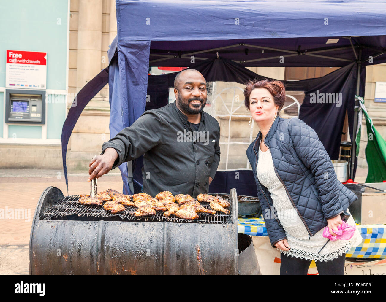 Cucina di strada venditore, vendita, piccante dei Caraibi di pollo alla brace,donna adulta, busbana francese le sue labbra, Newcastle Under Lyme Inghilterra Foto Stock