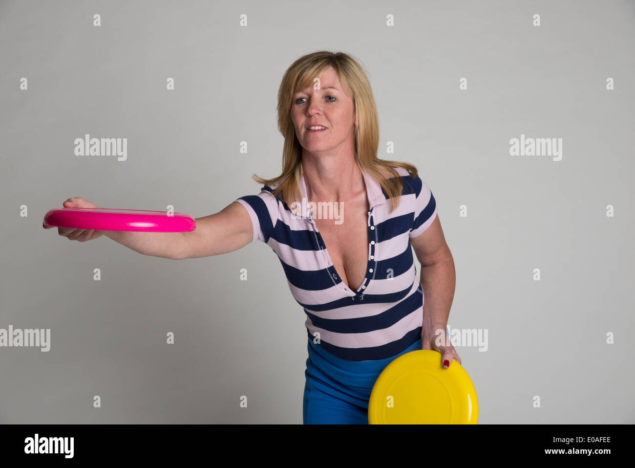 Ritratto di una donna di gettare un frisbee disc per mantenersi in forma Foto Stock