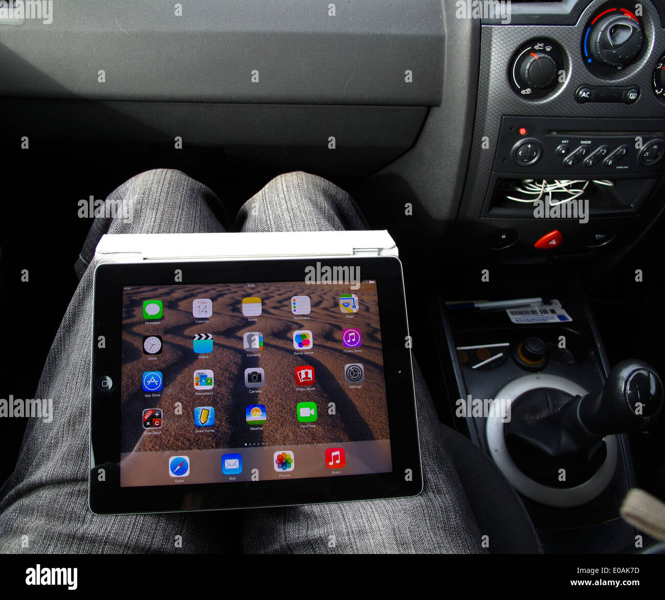 Uomo che utilizza iPad tablet sulle ginocchia nel sedile del passeggero di auto Foto Stock