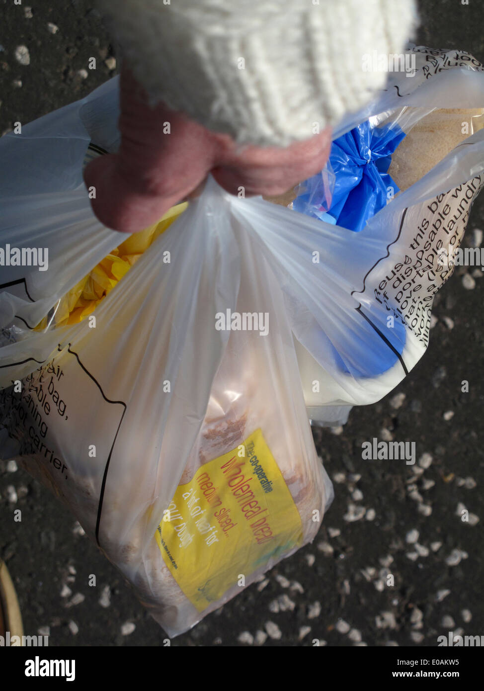 Il braccio e la mano che regge le borse della spesa di cibo Foto Stock