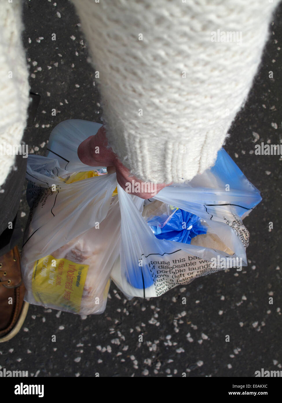Il braccio e la mano che regge le borse della spesa di cibo Foto Stock