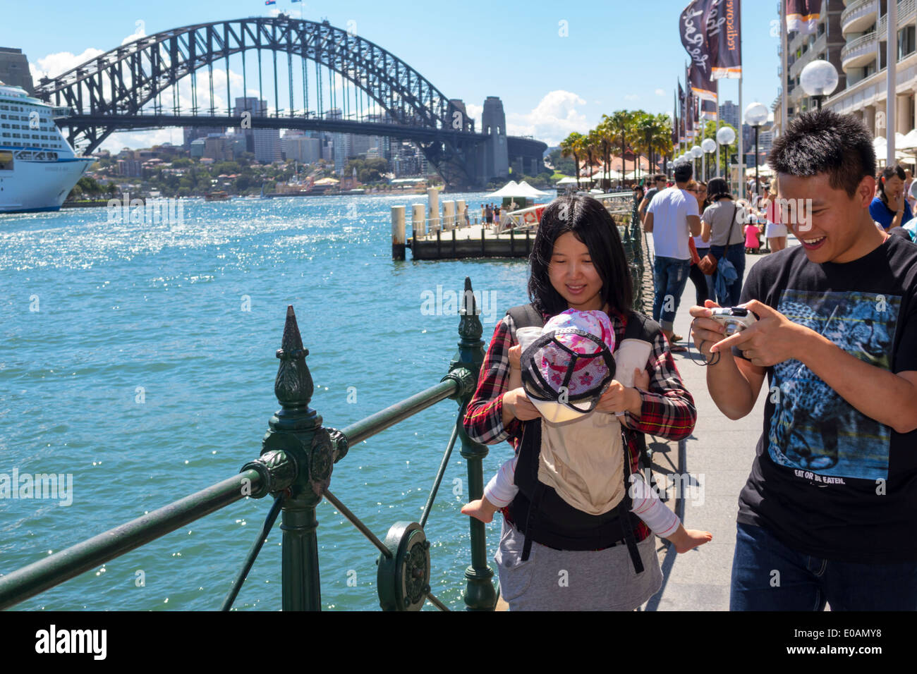 Sydney Australia,East Circular Quay,Promenade,Sydney Harbour Bridge,porto,uomo asiatico uomo maschio,donna donna donne,coppia,baby bebè bambini bambini,fam Foto Stock