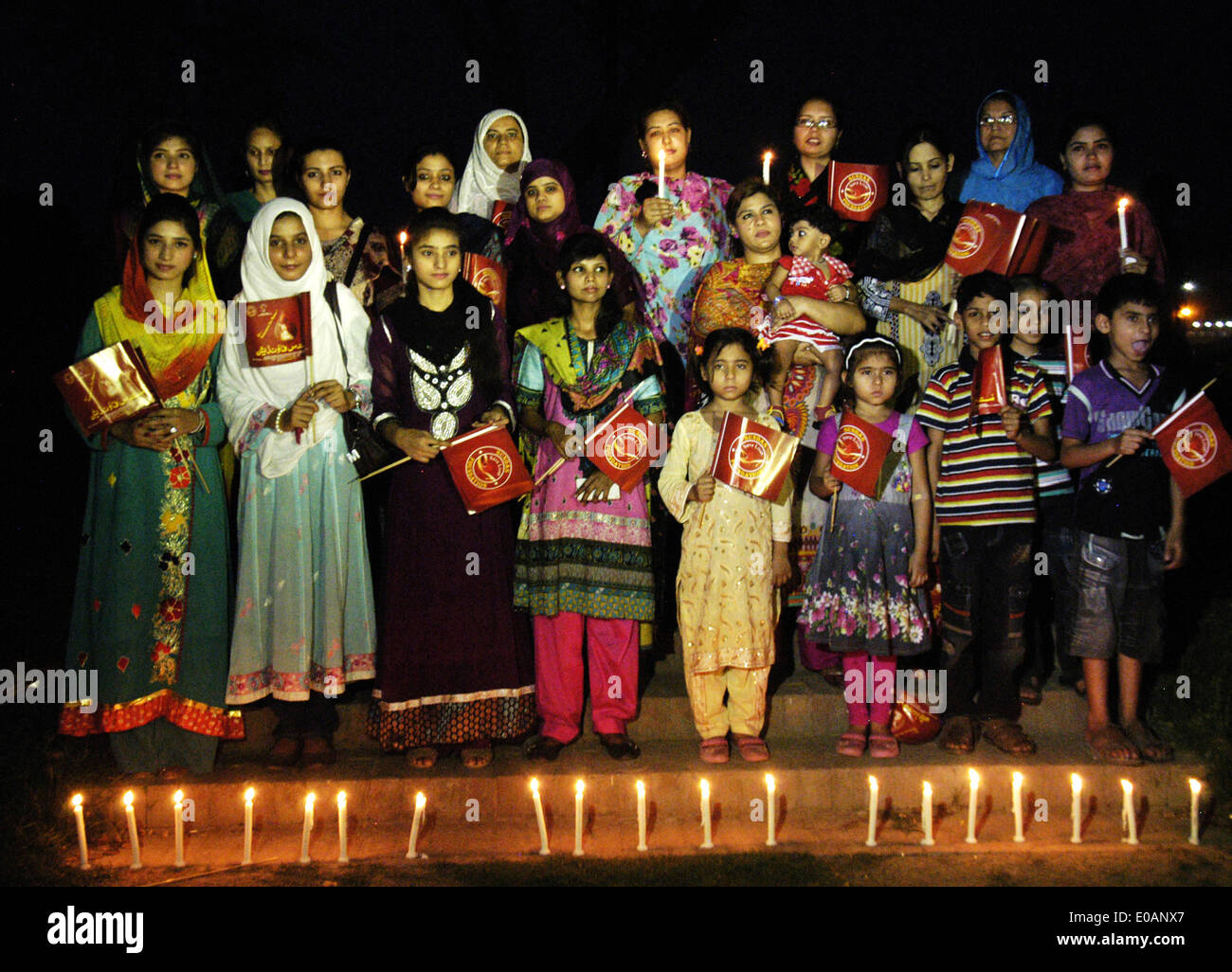 Lahore. Il 7 maggio, 2014. La popolazione pakistana comportano per le foto dietro le candele durante una cerimonia di International talassemia giorno in Pakistan orientale di Lahore, 7 maggio 2014. La talassemia è una malattia genetica del sangue che il paziente non è in grado di produrre abbastanza emoglobina, la sostanza nelle cellule rosse del sangue di trasportare ossigeno dai polmoni. © Sajjad/Xinhua/Alamy Live News Foto Stock