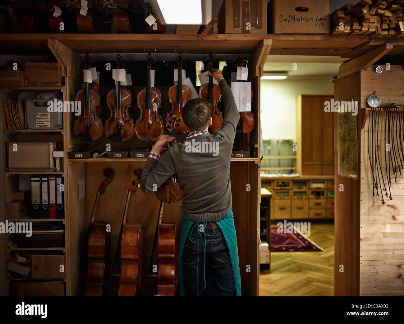 Liutaio nella sua bottega con violini ripristinato Foto Stock