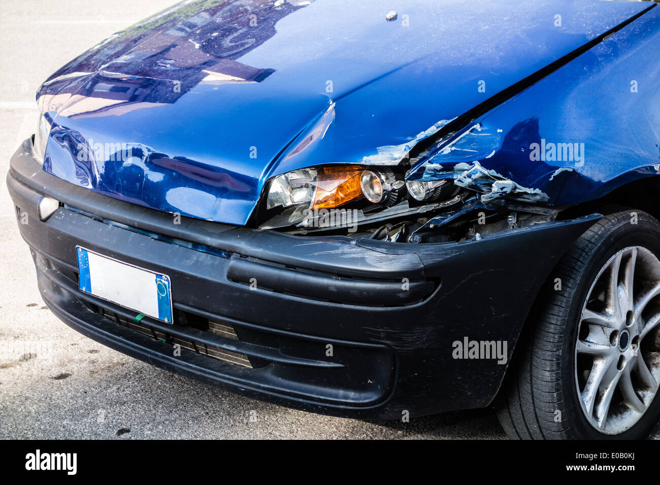 Una piccola auto blu danneggiato nella parte anteriore luci di sinistra Foto Stock