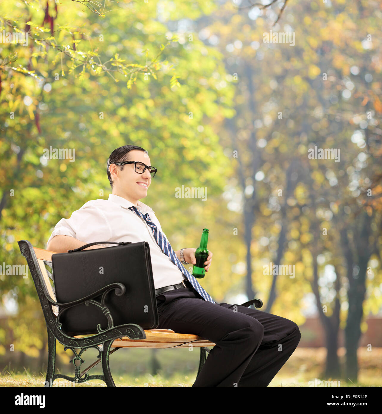 Imprenditore prendendo una pausa nel parco con una birra Foto Stock