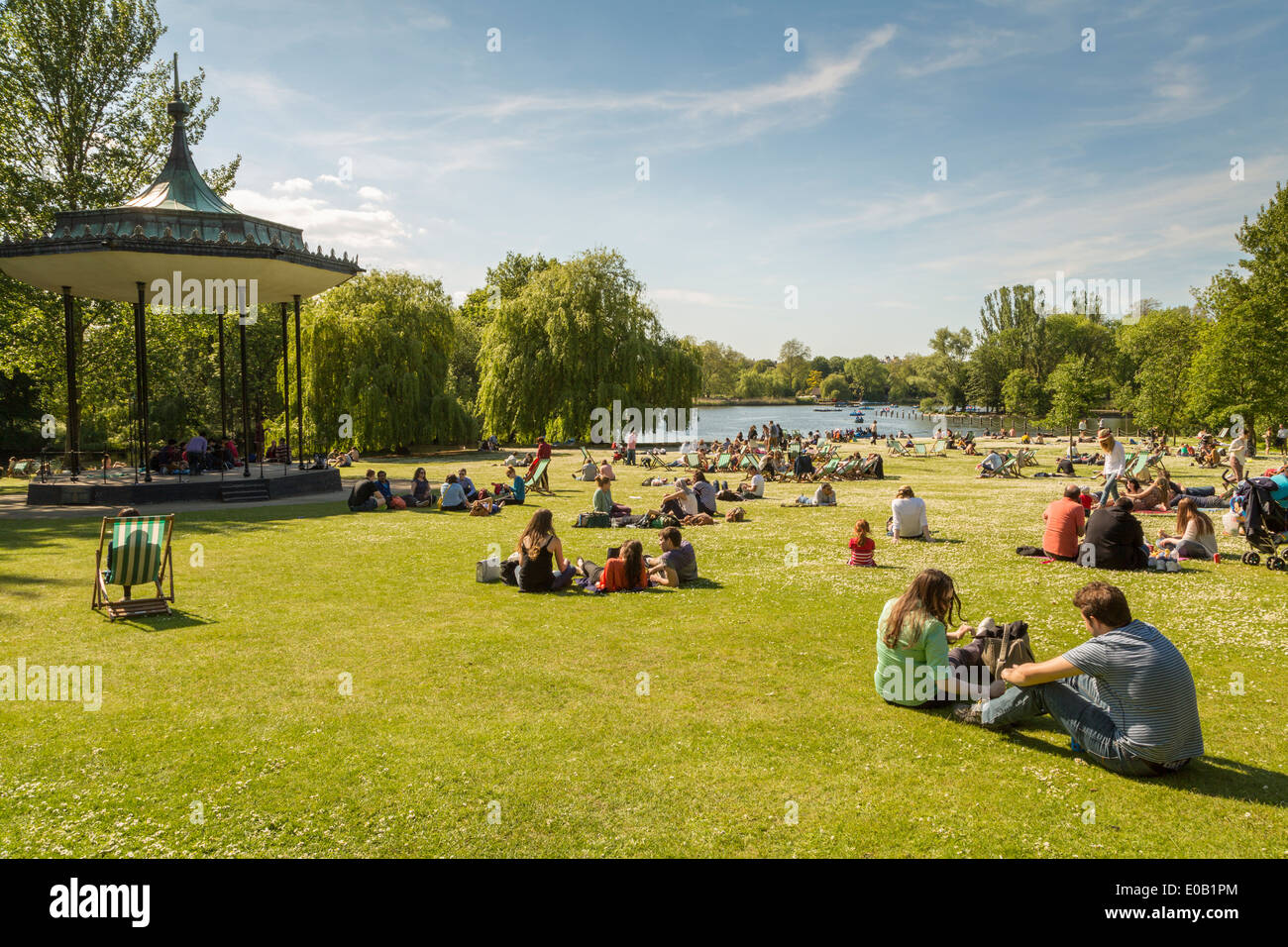 Giovani rilassarsi vicino alla banda di stand in estate il sole, Regents Park Londra Inghilterra REGNO UNITO Foto Stock