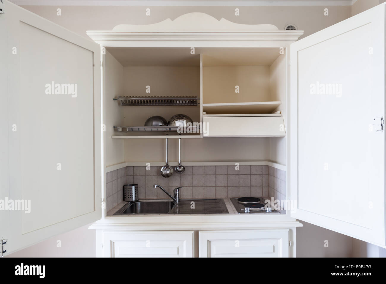 Una piccola cucina contenuta all'interno di un armadio in legno Foto Stock Una piccola cucina contenuta all'interno di un armadio in legno Foto Stock