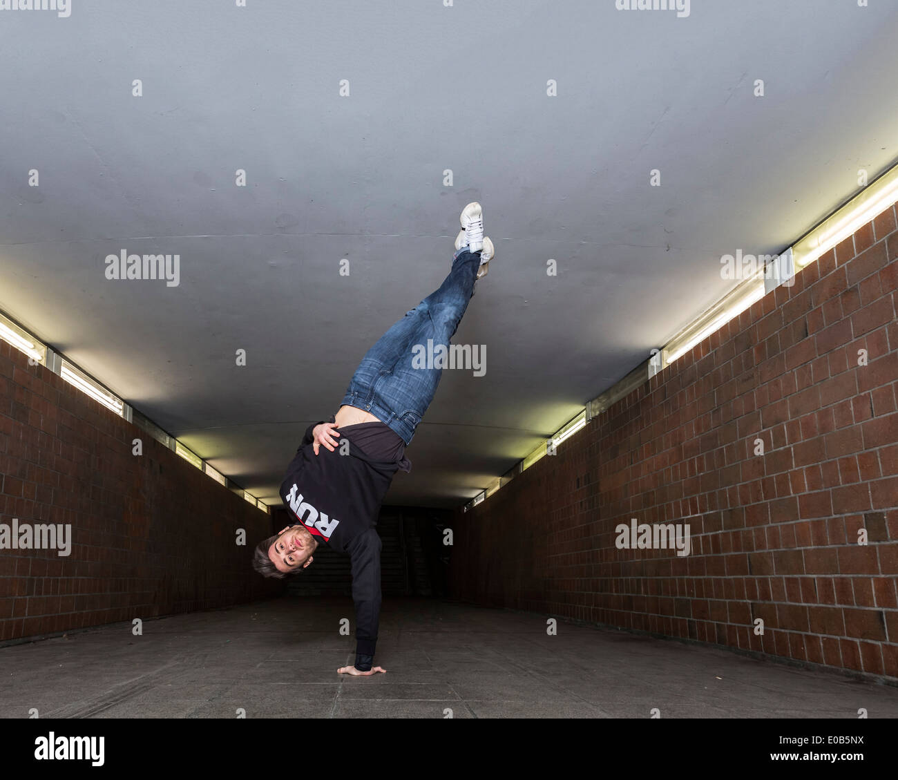 Giovane breakdancer eseguendo un handstand nel sottopassaggio Foto Stock