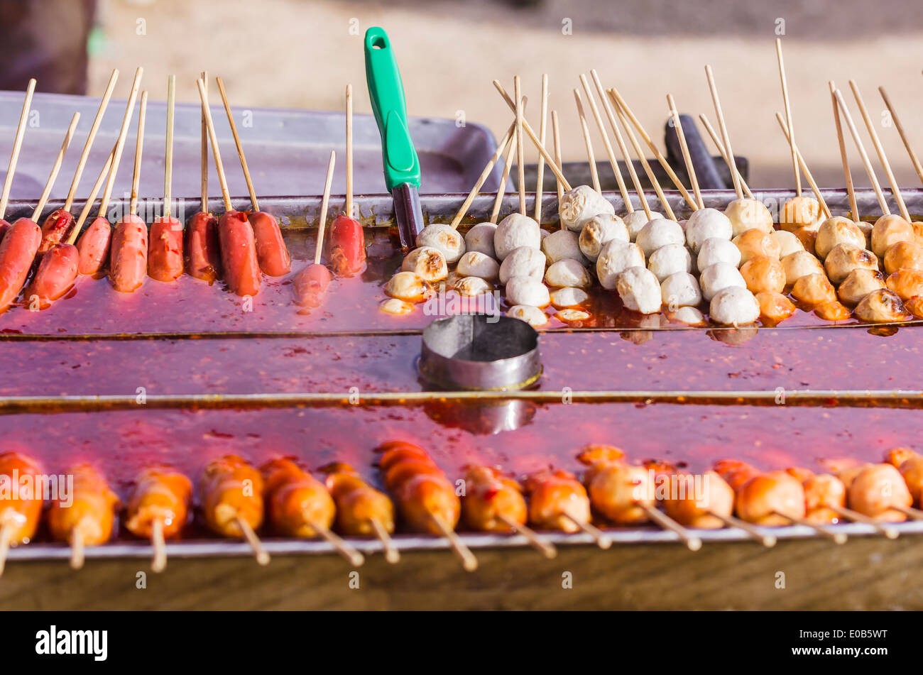 Thailandia, Phang Nga, mercato settimanale vicino Khuekkhak, rotoli di pasta e salsicce spiedini Foto Stock