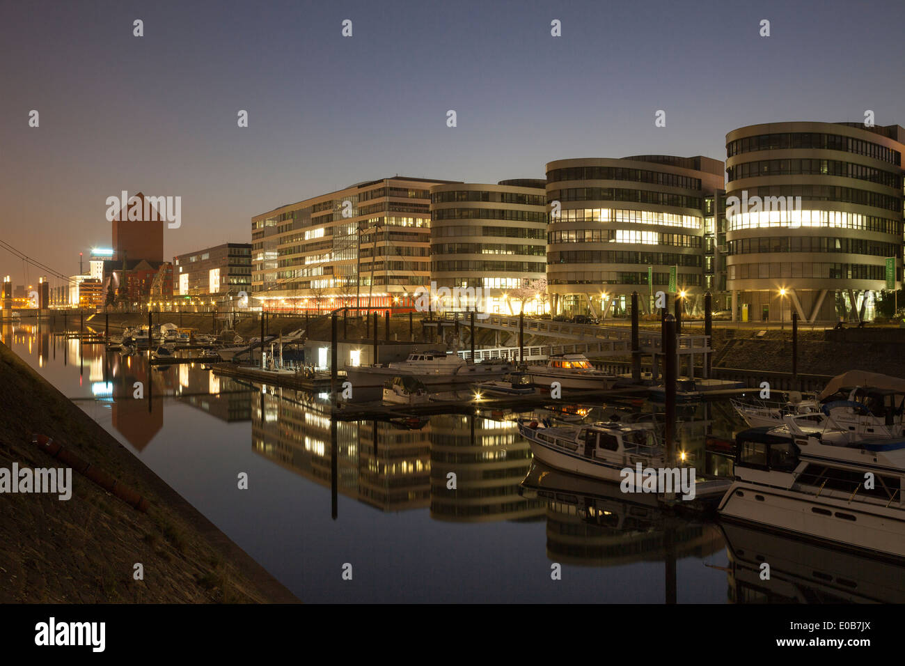 In Germania, in Renania settentrionale-Vestfalia, Duisburg, porto interno e di edifici per uffici, cinque barche, di notte Foto Stock