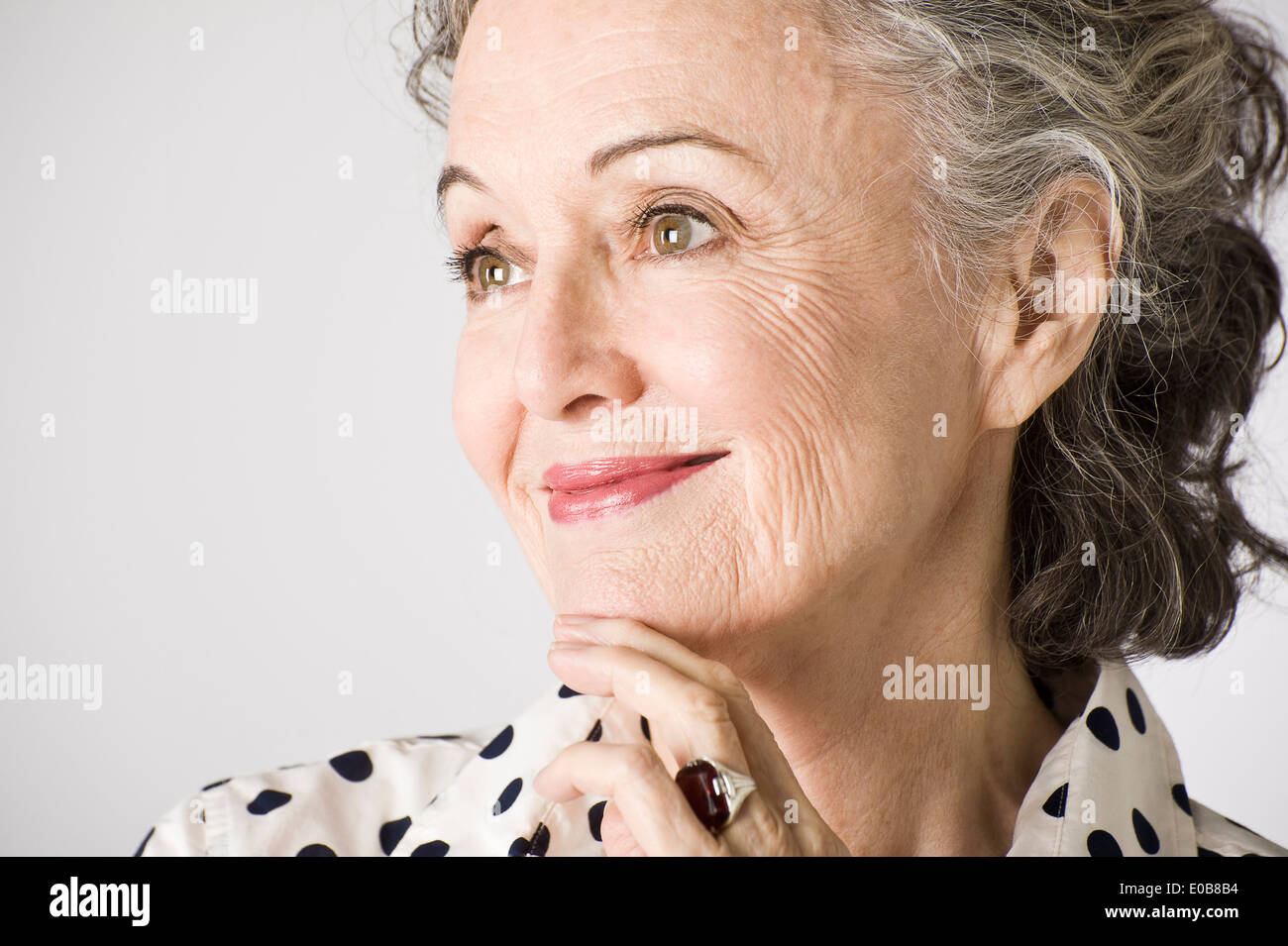 Ritratto di donna senior, mano sul mento, sorridente Foto Stock