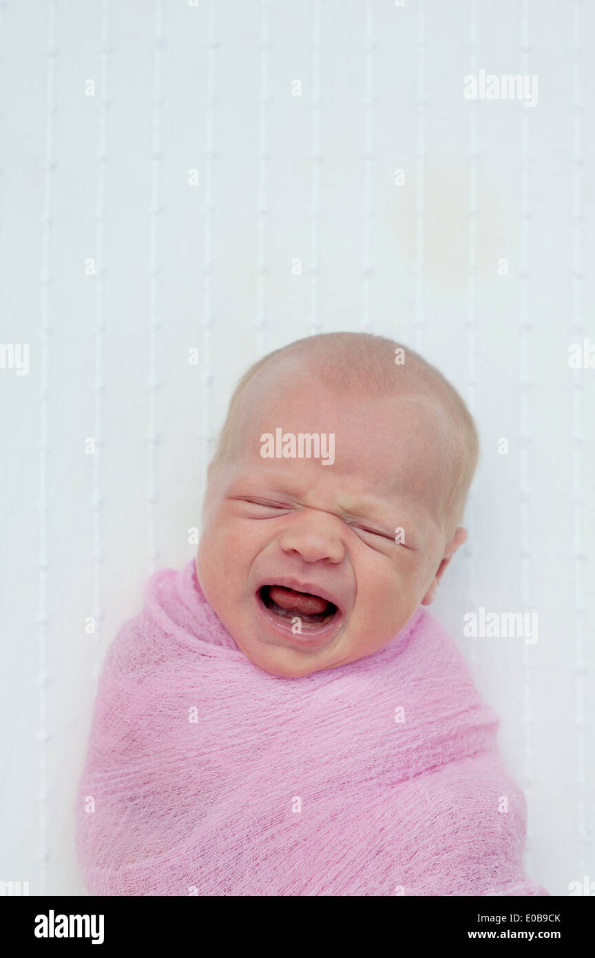 Il bambino piange, avvolto in una coperta Foto Stock