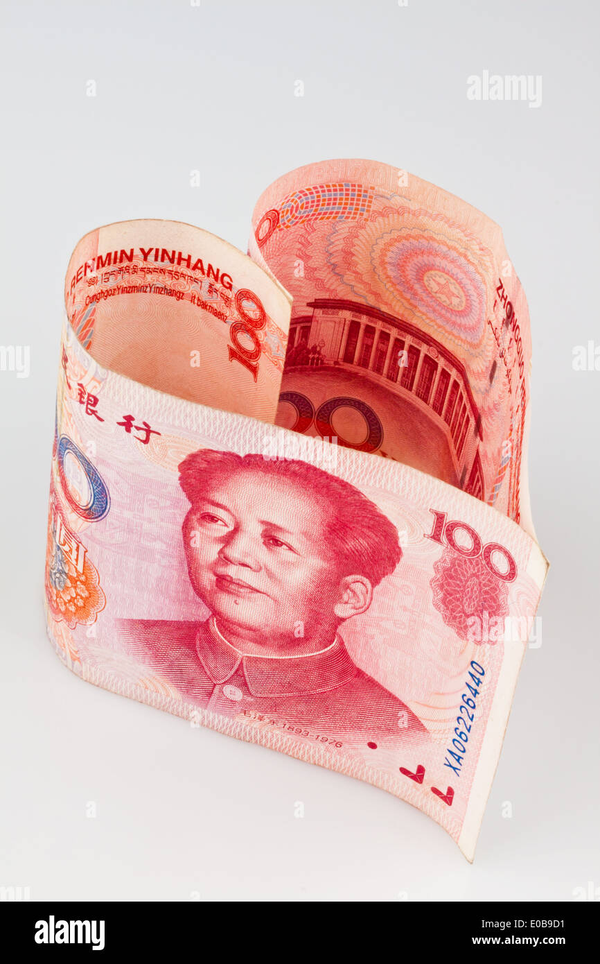 Yuan cinese della nota banca in forma di cuore davanti a uno sfondo grigio, Chinesischer Yuan Geldschein in Herzform vor grauem Hintergrund Foto Stock