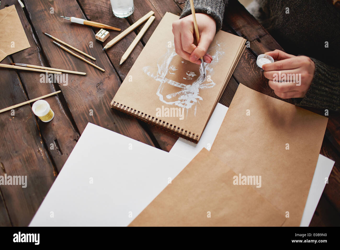 Immagine del giovane di mani umane di disegno con gouache bianco Foto Stock