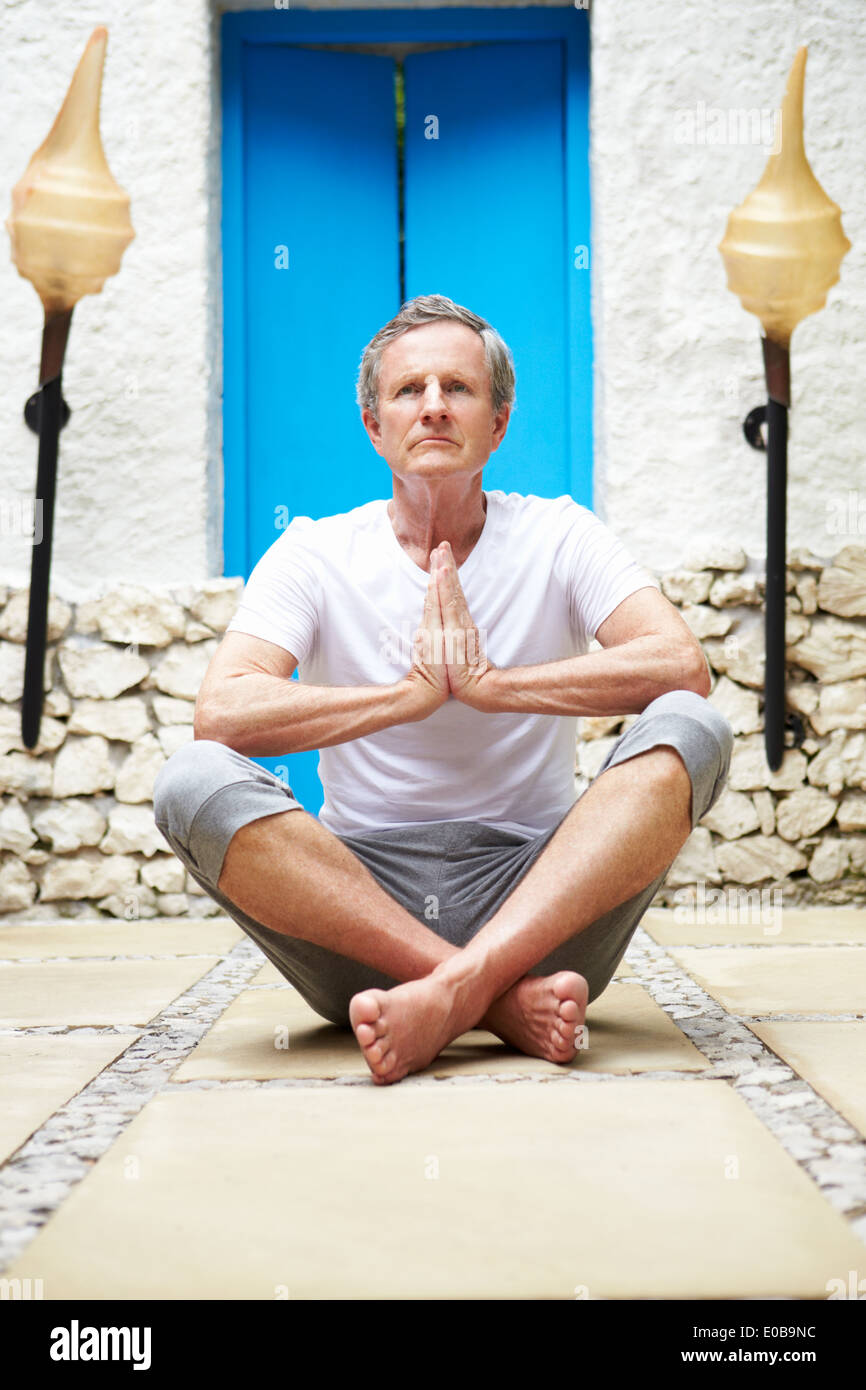 Senior uomo meditando all'aperto a Health Spa Foto Stock