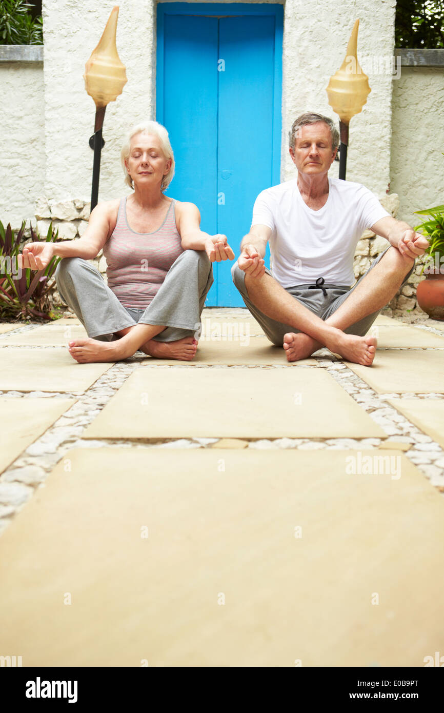 Coppia senior meditando all'aperto a Health Spa Foto Stock
