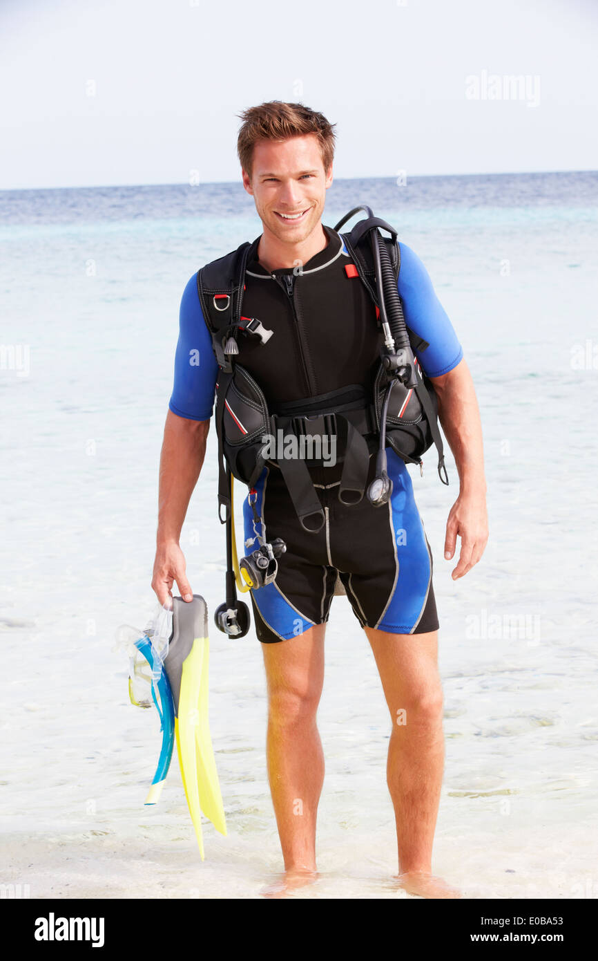 Uomo con attrezzatura subacquea godendo di vacanze in spiaggia Foto Stock