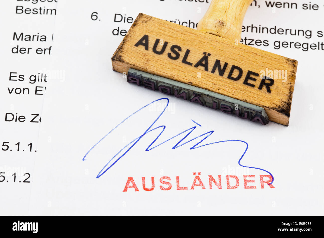 Un francobollo di legno si trova su un documento. Etichetta tedesca: straniero, Ein Stempel aus Holz liegt auf einem Dokument. Deutsche Aufschrift: Foto Stock