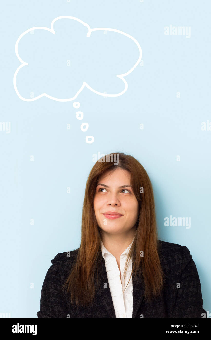 Bella donna d'affari sorridente e il pensiero di un'idea brillante con il pensiero il cloud sopra la sua testa Foto Stock