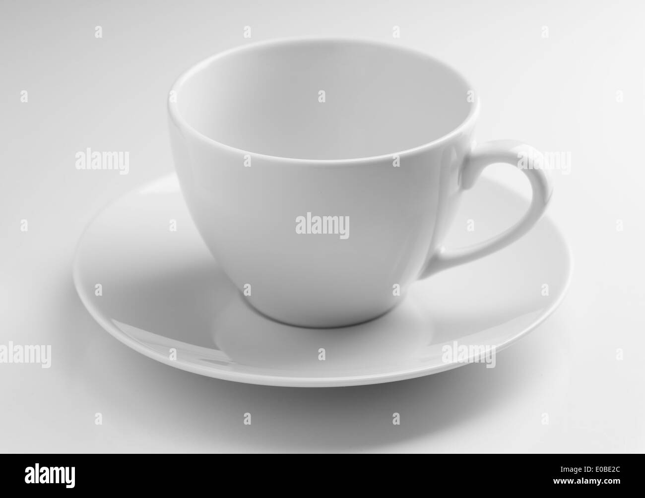 Vuoto tazza ceramica con un piattino su sfondo grigio Foto Stock