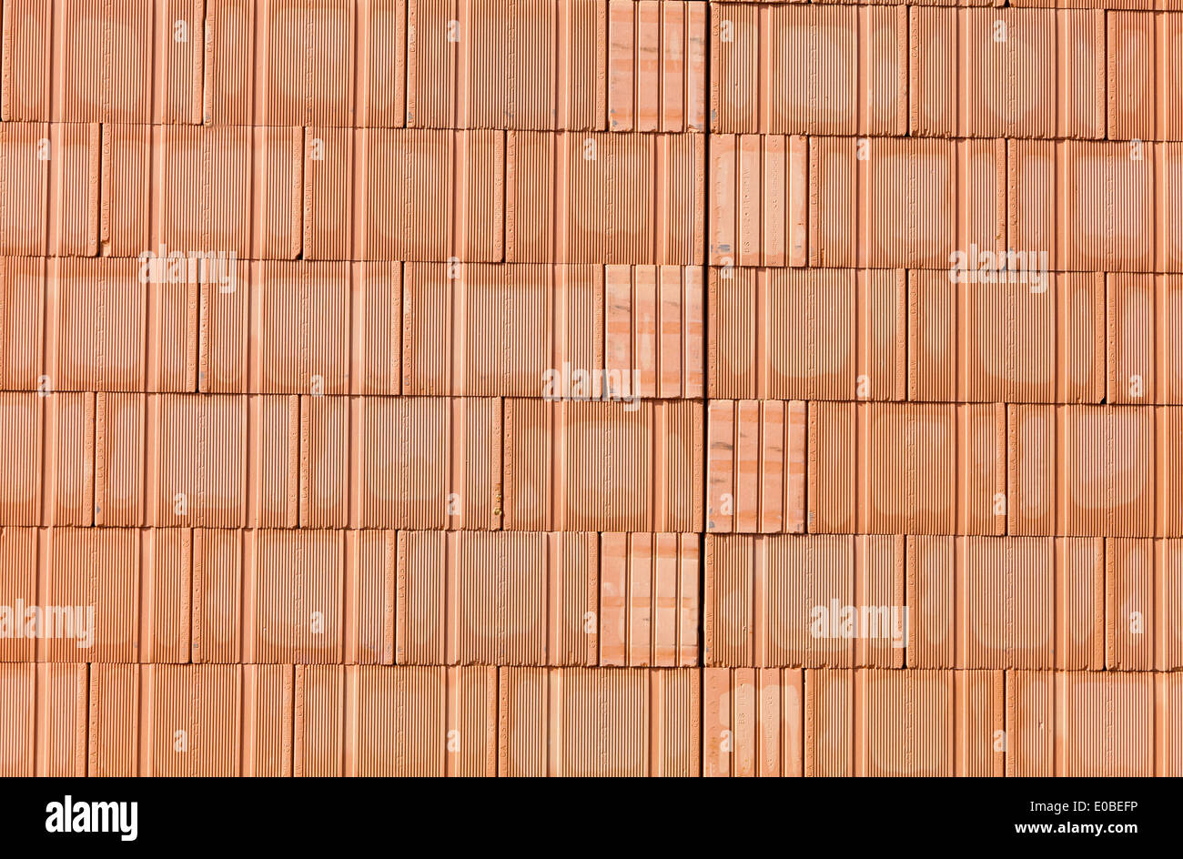 Un nuovo muro di mattoni con un guscio in diretta su un sito di costruzione. Sfondo., Ein neue Ziegelmauer bei einem Rohbau haus auf einer Baustel Foto Stock