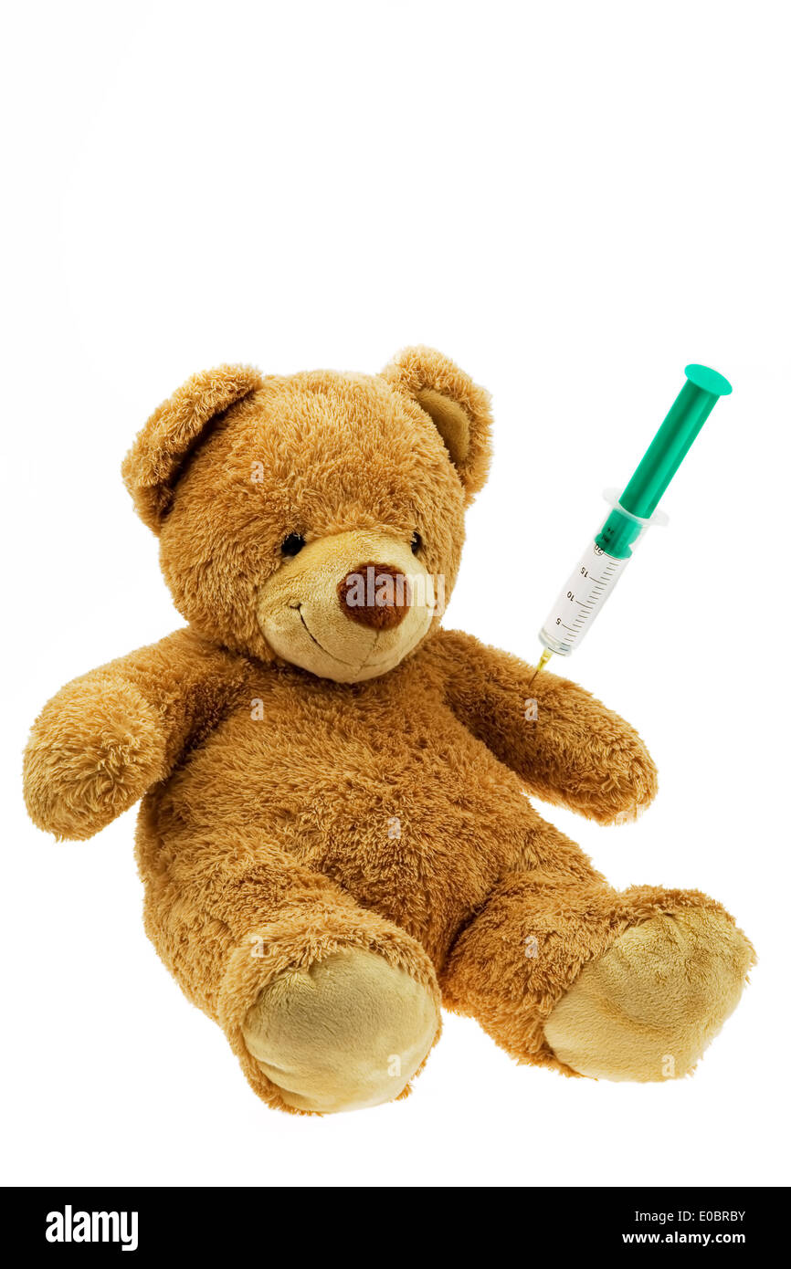 En orsacchiotto ottiene una iniezione. Inoculare e siringa., En Teddybaer bekommt eine Injektion. Impfen und Spritze. Foto Stock