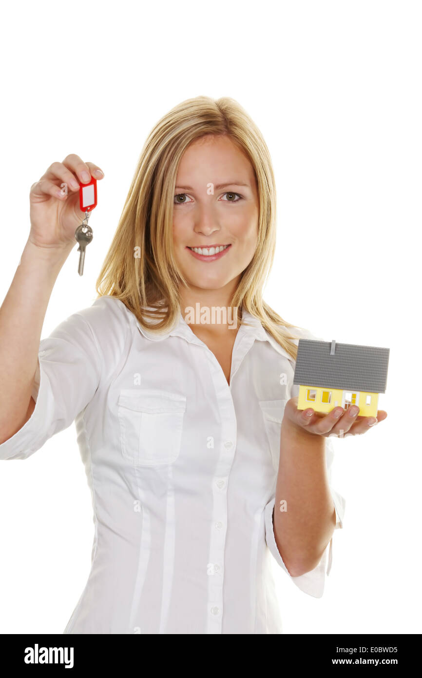 Una giovane donna con un modello di casa e la chiave piatta., Eine junge Frau Mit einem Modell Haus und Wohnungsschluessel. Foto Stock