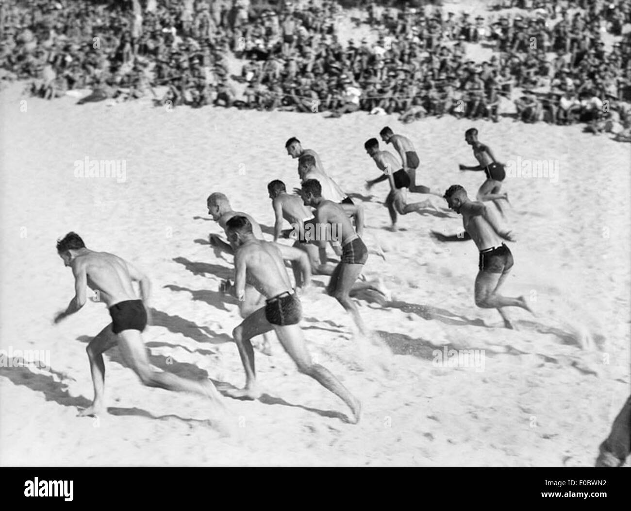 Una vivace scena di sport da spiaggia, con i partecipanti che si godono varie attività sulla sabbia sotto i limpidi cieli estivi. L'ambiente della spiaggia mette in risalto l'atmosfera attiva e vibrante delle attività ricreative estive all'aperto. Foto Stock