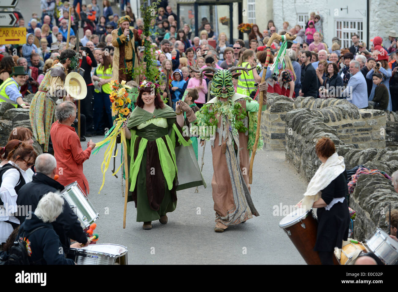 Il Green Man Festival a Clun nello Shropshire. L'uomo Verde e la sua Regina di Maggio attraversano l'antico ponte dopo aver sconfitto la Regina Frost. Foto Stock