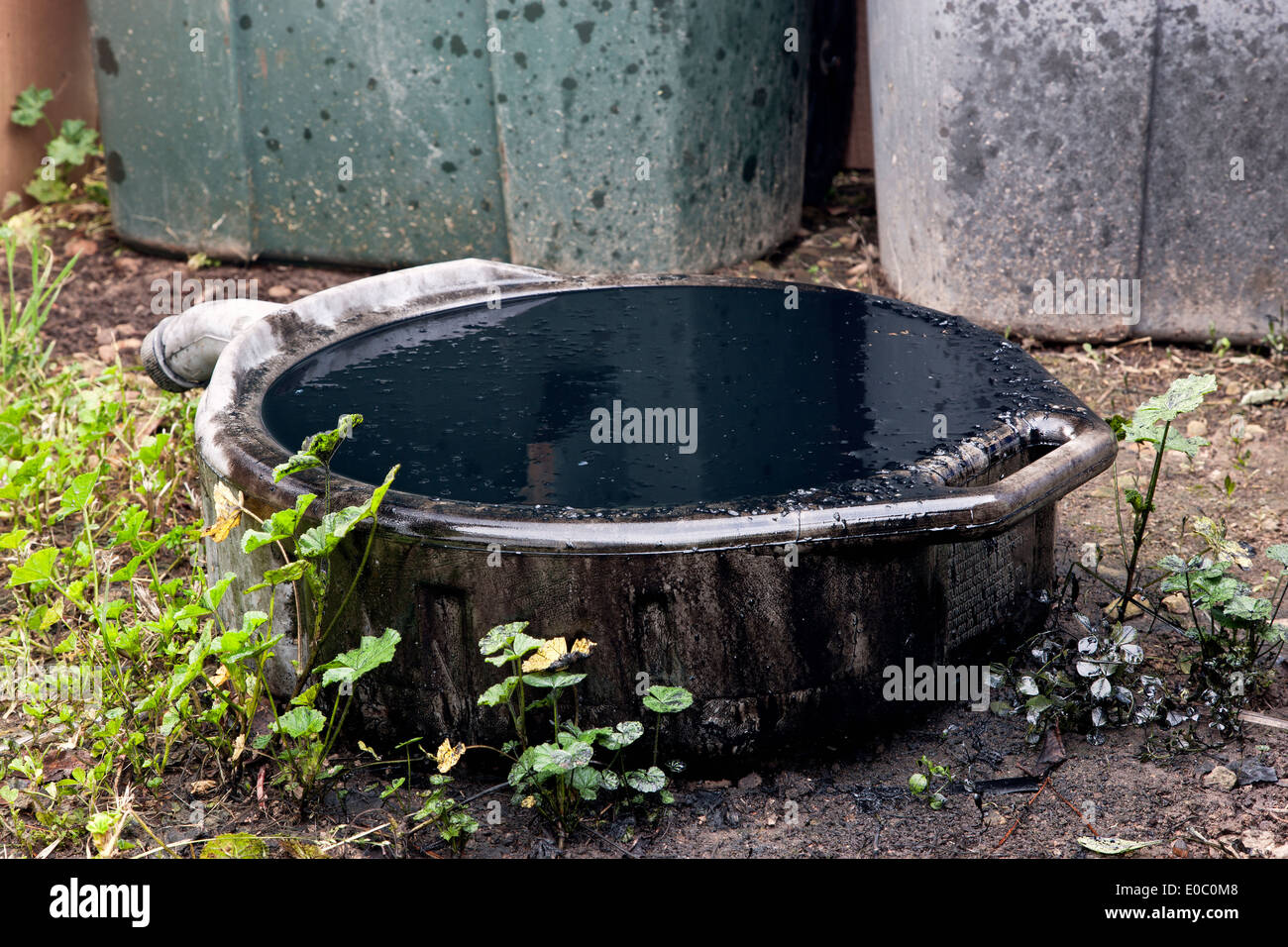 Vaschetta di scarico olio fuoriuscite, traboccante contenente sporco di olio motore. Foto Stock