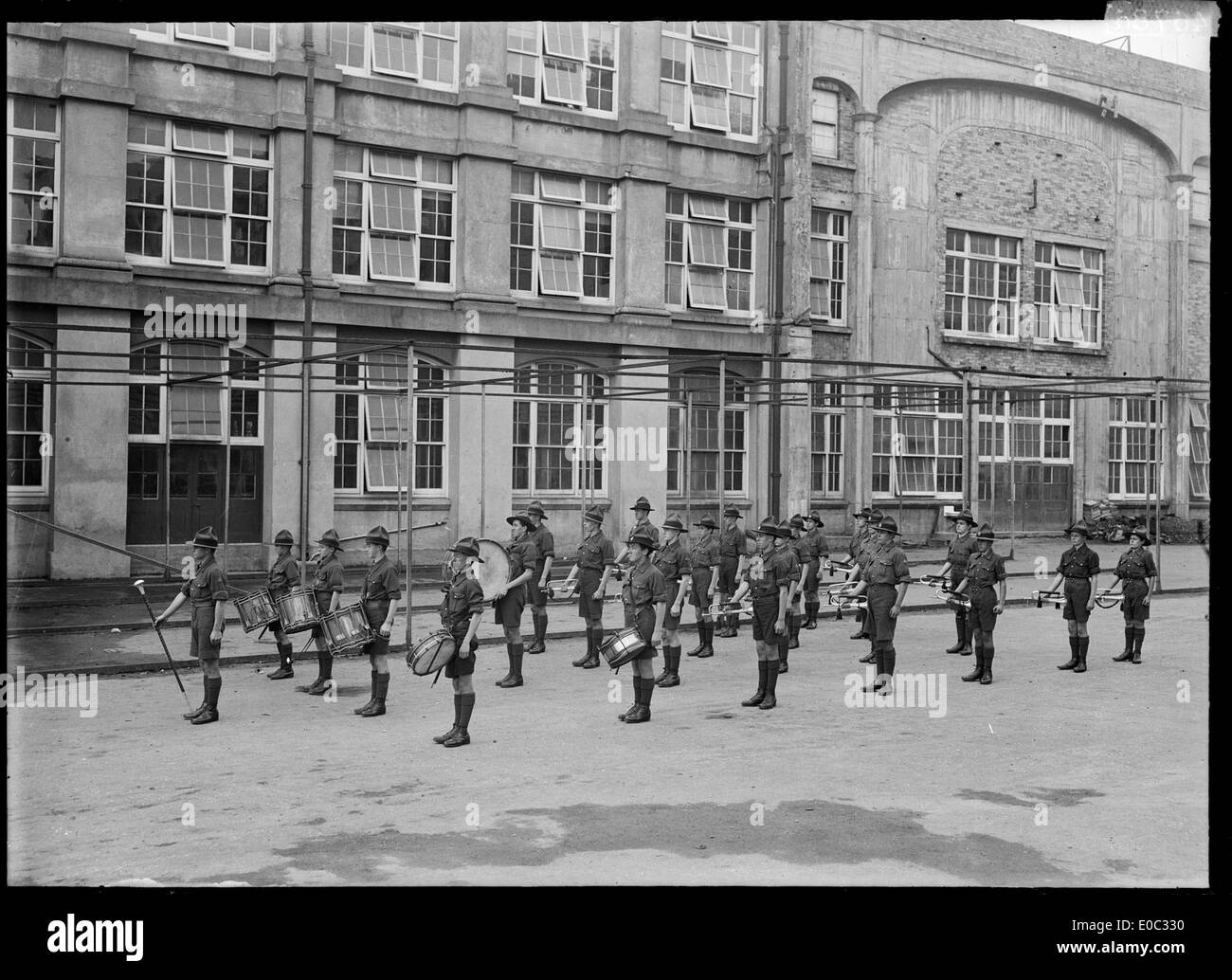 Questa immagine cattura la Christchurch West High School Drum & Bugle Corps in parata intorno al 1915, mostrando il coinvolgimento della scuola in spettacoli in stile militare e la tradizione delle bande di marcia scolastiche. Foto Stock