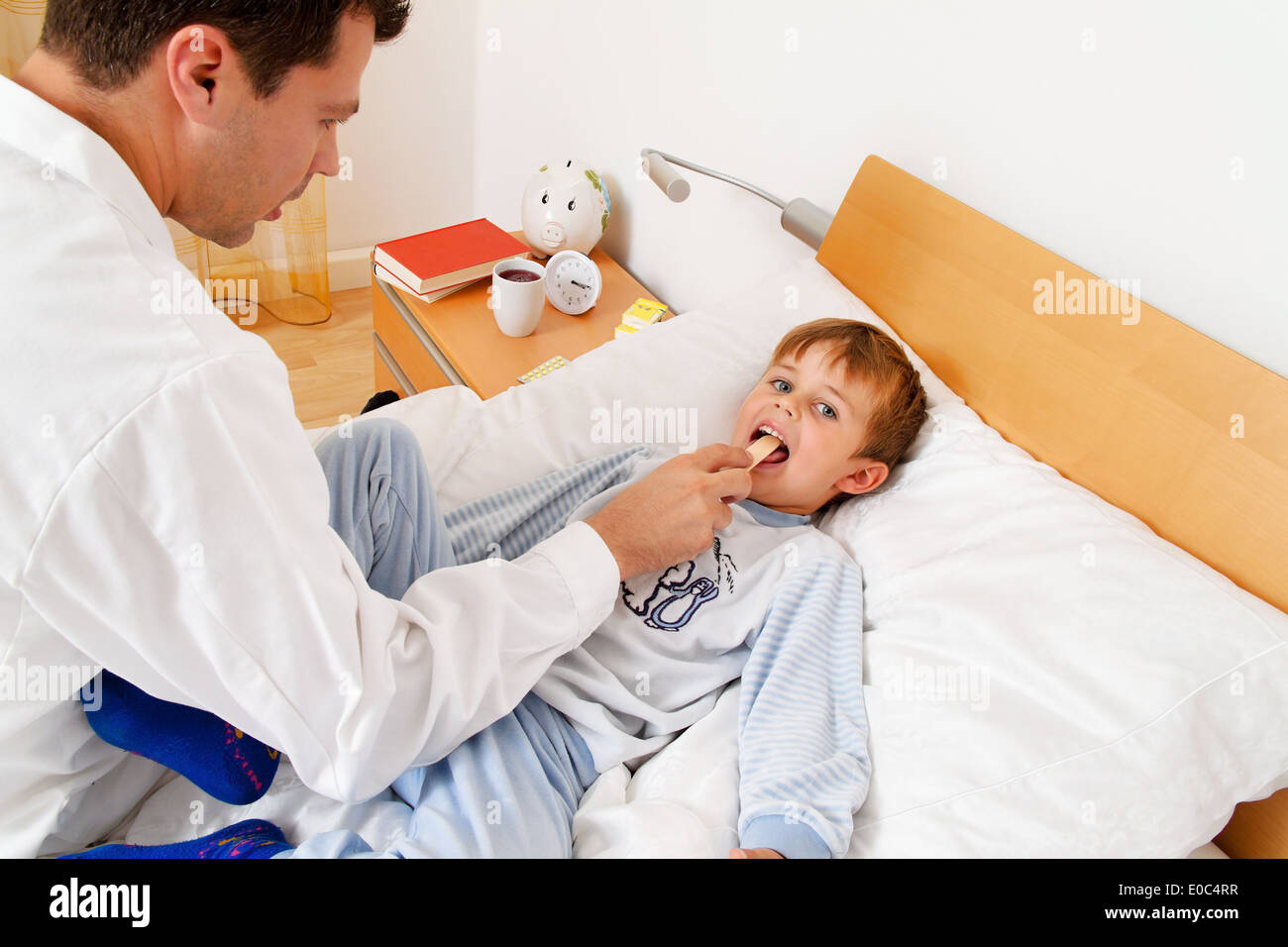 Un medico in casa visita. Se un bambino malato esamina., Ein Arzt bei Hausbesuch. Untersucht ein krankes tipo. Foto Stock