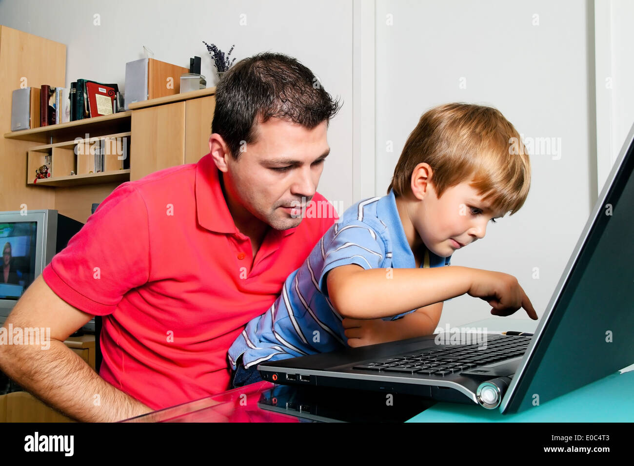 Un uomo e bambino con computer portatile nella piana., Ein Mann und tipo mit computer laptop in Wohnung. Foto Stock