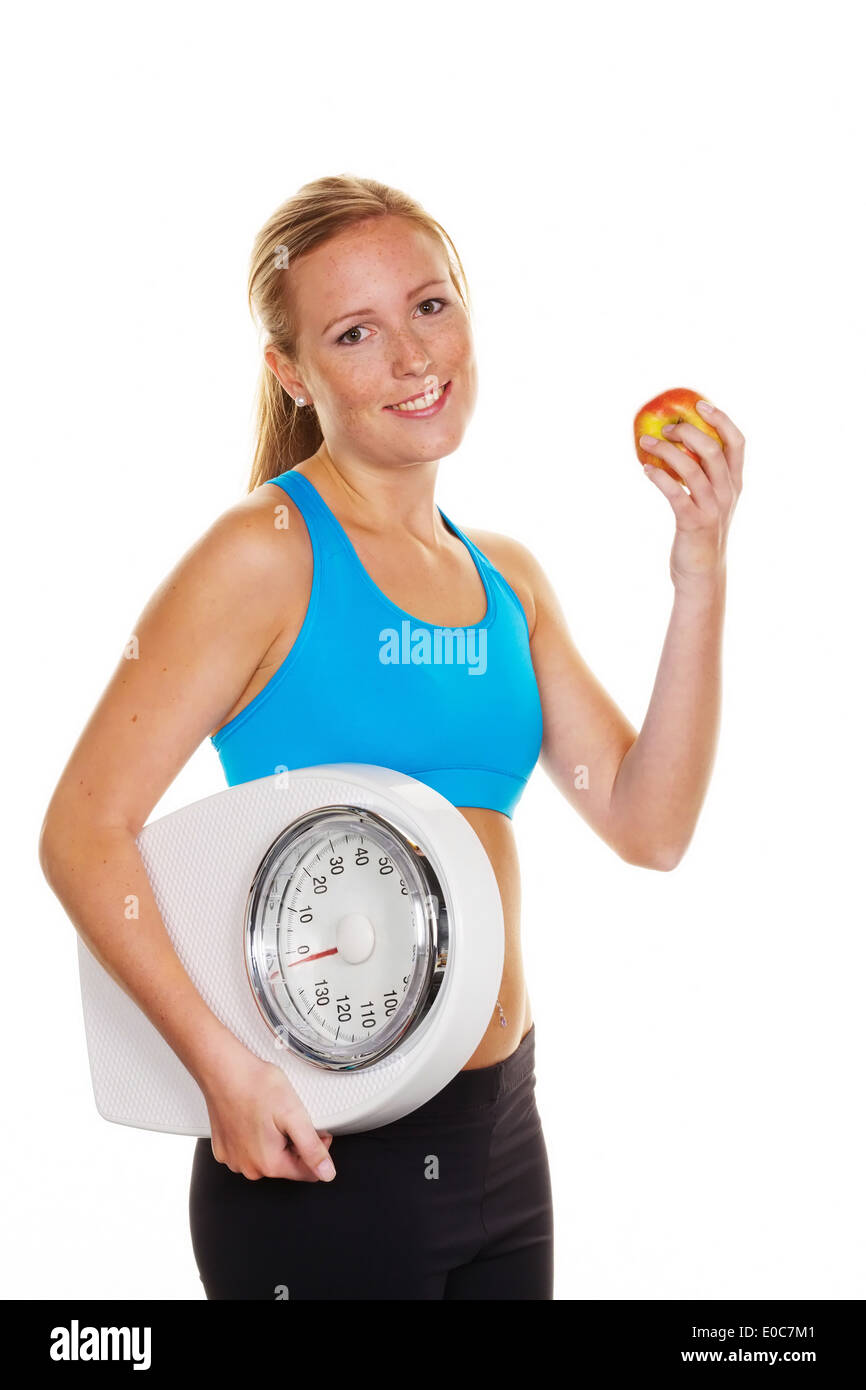 Giovane donna con scale di personali e Apple. Dieta di successo, Junge Frau mit Personenwaage und Apfel. Erfolgreiche Diaet Foto Stock