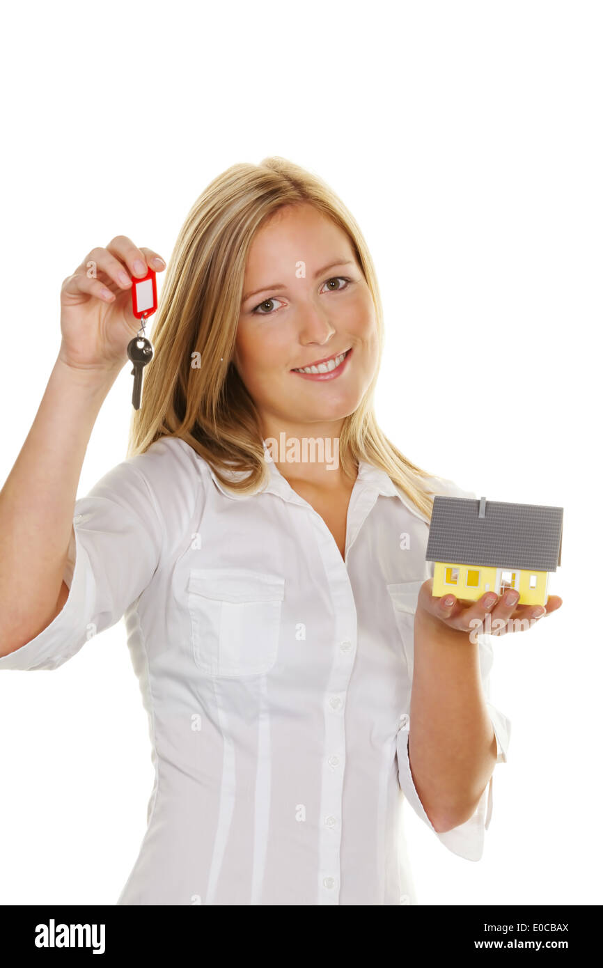 Una giovane donna con un modello di casa e la chiave piatta., Eine junge Frau Mit einem Modell Haus und Wohnungsschluessel. Foto Stock